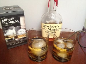 Photo of two Bourbon on the Rocks. Left glass contains a single ice sphere. Right glass contains 5 ice cubes.  The right also has the temperature probe used in this experiment.  Both glasses contain 3 fl. oz. of bourbon.  Note: this photo is not from the actual experiment and was taken later.