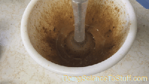 animated gif showing weakly foamed dalgona liquid pulsing out the gaps of a stick blender
