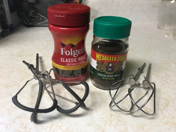 Jars of Folgers classic roast instant coffee and Medaglia D'oro instant espresso next to two styles hand mixer beaters
